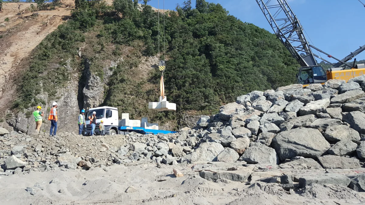 Dalgakıran yanında beton koruma elemanı kaldıran vinç