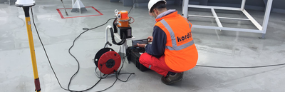 Kordil surveyor operating positioning equipment beside a GNSS antenna
