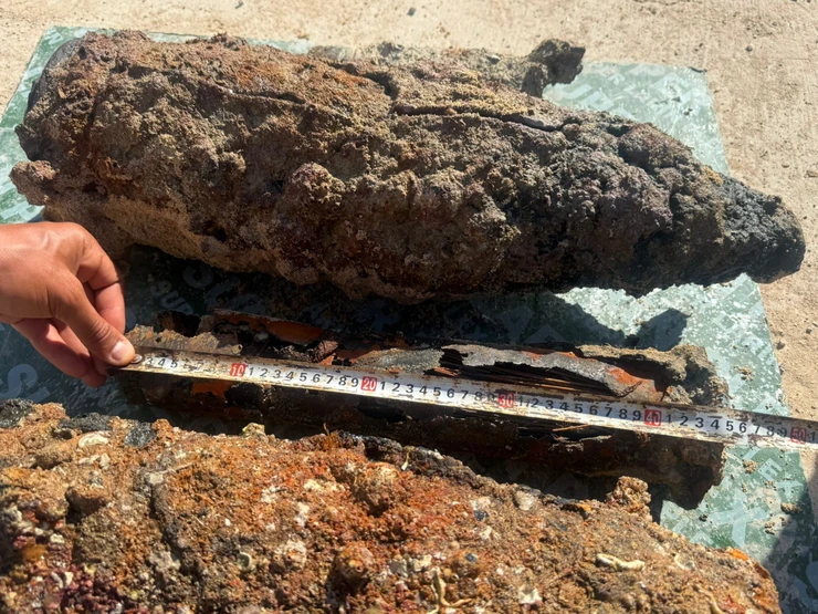 Corroded seabed objects documented with a measuring scale during target verification.