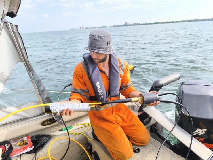Surveyor preparing a marine magnetic sensor and cable for deployment