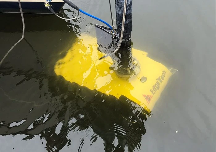 Yellow survey sensor deployed beside the vessel