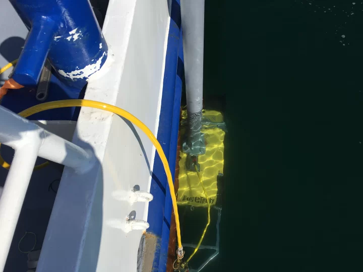 EdgeTech sub-bottom profiler submerged alongside the survey vessel with mounting pole and cable